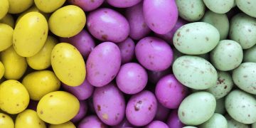 A pile of yellow, pink and green mini egg sweets.