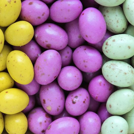 A pile of yellow, pink and green mini egg sweets.