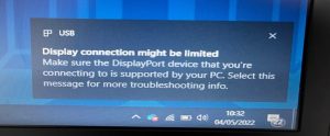 A computer screen displaying an error message: 'Display connection might be limited. Make sure the DisplayPort device that you're connecting to is supported by your PC. Select this message for more troubleshooting info.'.