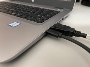 A laptop with USB-C and Display port cables connected.