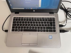 A laptop with the USB cables for keyboard and mouse connected, as well as the display port.